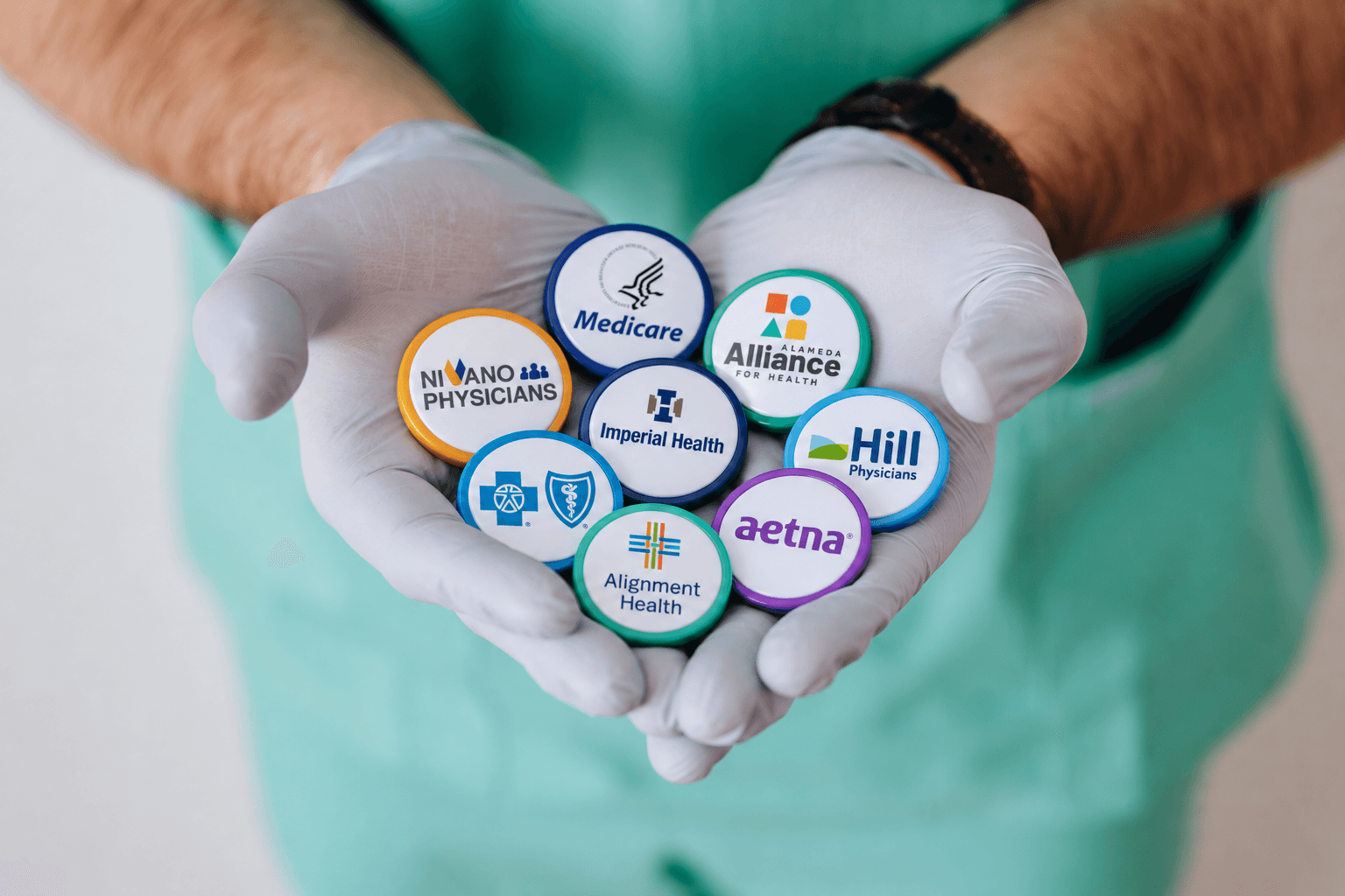 A clinician holding badges for the health plans Mission works with